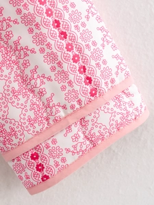 Detailed macro view of pink floral print fabric with premium piped edge stitching