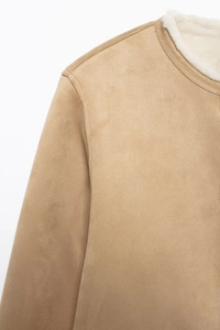 Detail shot of light camel suede jacket with white faux shearling lining and neat shoulder seams