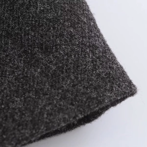 Macro detail of the dark grey textured wool fabric with premium stitching on women's coat