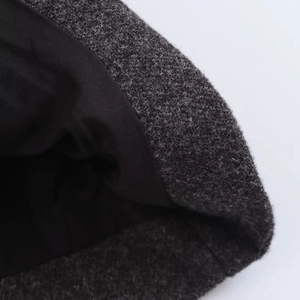 Close-up of textured dark grey wool fabric and smooth black lining on a winter coat