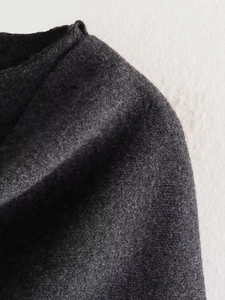 Macro shot of dark grey knit fabric texture on the collar and shoulder of the jacket