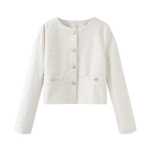 Détail rapproché de la texture du tweed ivoire et boutons dorés élégants de la veste