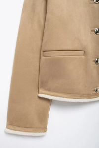 Detail of khaki faux suede jacket with white shearling trim and silver metal buttons
