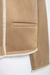 Detail of camel shearling jacket showing suede texture, white faux fur lining, and pocket