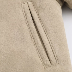 Dettaglio macro della tasca a filetto su questa giacca beige in finta pelle di pecora