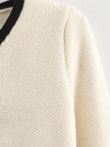 Close-up of contrast rib collar and premium knit texture on cream-colored cardigan