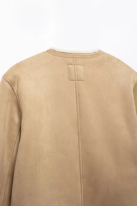 Detail of camel suede jacket back featuring white plush lining and precise stitching