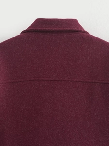Detail view of burgundy woolen jacket showing the collar seam and neat stitching quality