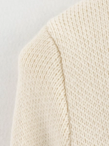 Detailed view of the high-quality shoulder stitching on the cream knit cardigan jacket