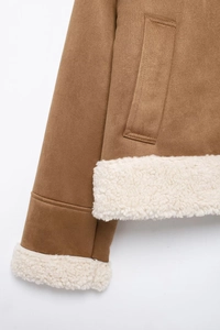Detailed view of the stitching and lamb-like faux fur lining on brown suede jacket cuff