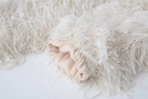 Close-up of fluffy faux fur sleeve with luxury silk lining and metallic trim details