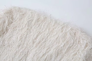 Close-up of off-white faux fur texture with delicate metallic trim for winter coat