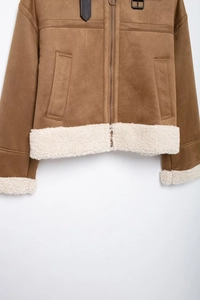 Detail of brown suede jacket showing metallic zipper and white faux shearling fur lining