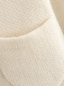 Detailed macro view of cream knit fabric texture and premium pocket stitching detail