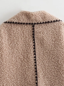Détail de la veste en polaire beige avec bordure ondulée foncée au col et au dos