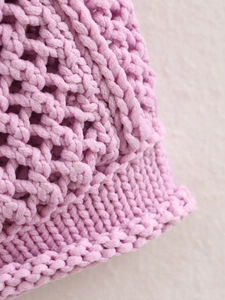 Close-up of pink knit cardigan showing delicate diamond mesh and ribbed edge texture