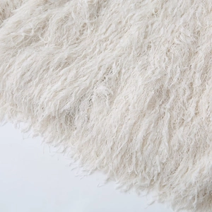 Detailed close-up showing soft off-white faux fur texture and delicate tassel fibers