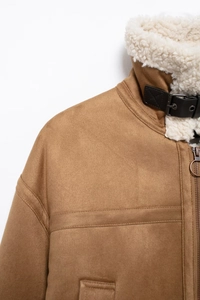 Detail view of brown suede jacket with white faux shearling collar and metal ring zipper