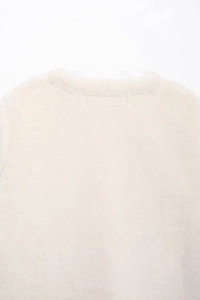 Close-up of soft faux fur texture and refined edge stitching on a cream jacket