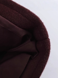 Gros plan d'une veste courte bordeaux avec tissu en laine premium et doublure soyeuse