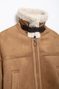 Close-up of brown suede jacket with white faux shearling collar and leather buckle detail