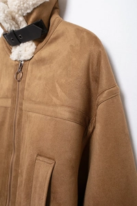 Detail of brown suede jacket with faux shearling collar and black leather buckle strap