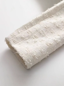 Manche de veste en tweed crème élégante avec bords effilochés et texture raffinée