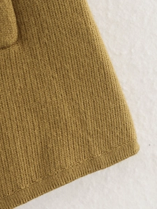 Detail shot of camel ribbed knit fabric showing tight vertical texture and neat stitching
