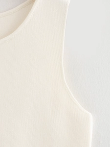 Gros plan détaillé montrant la texture en maille fine et l'encolure d'un gilet sans manches