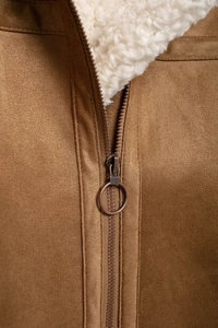 Detail of vintage ring zipper on brown faux suede and white sherpa fleece jacket