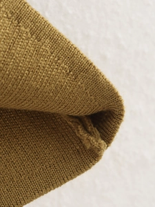Close-up of mustard yellow V-neck knitted vest showing soft plain stitch texture