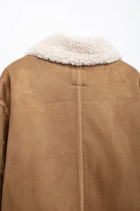 Detail view of the back seam on a brown suede sherpa-lined jacket with a white collar