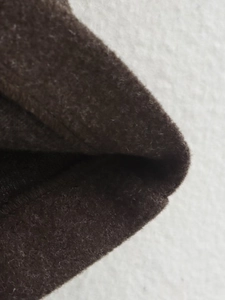 Close-up of thick dark brown fleece fabric texture and seam detailing of jacket