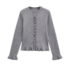 Detailed view of the ruffle trim on cuffs and hem of this grey knitted cardigan sweater