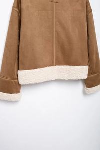 Close-up showing white faux shearling trim on the brown suede jacket cuffs and hemline