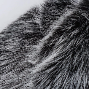 Macro shot of faux fur texture with black roots and silver tips for women's jacket