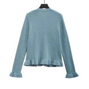 Detailed view of Morandi blue knitted sweater featuring ruffle hem and cuff accents