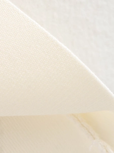Gros plan sur la texture du tricot crème avec détails de couture et motif de tissage doux