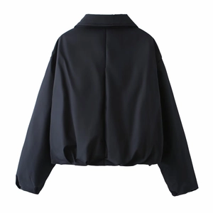 Détail de l'ourlet élastique et du col arrière de cette veste courte noire coupe ample
