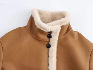 Gros plan sur le col en polaire crème et les boutons de la veste en cuir marron vintage