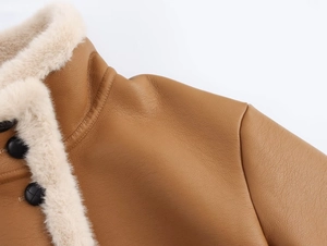 Détail de la veste en cuir marron avec bordure en peau de mouton blanche et boutons tressés
