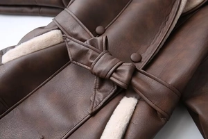 Detail of dark brown faux shearling coat with leather waist belt and soft fleece lining