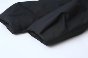 Détail du poignet de la veste noire coupe-vent avec une texture de tissu de qualité