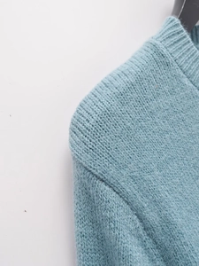 Detail of light blue knit cardigan showing wood ear ruffle collar and soft texture