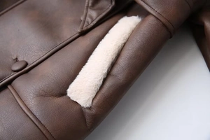 Detail of dark brown faux leather coat featuring plush white fur collar and buttons