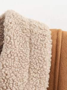 Nahaufnahme der braunen Wildlederjacke mit weichem cremefarbenem Sherpa-Lammfellkragen