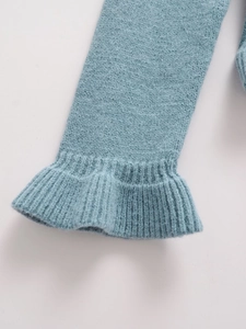 Detailed macro view of ruffles on the gray-blue knit cardigan cuff with ribbed texture