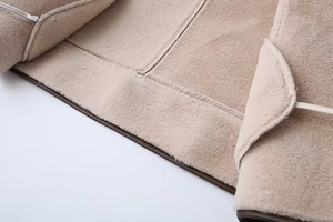 Detailed close-up of thick beige faux shearling lining with premium stitching for warmth