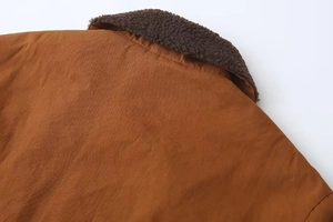 Détail du col d'une veste d'hiver montrant la doublure en peau de mouton et le sergé