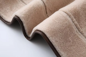 Detailed close-up of warm beige faux shearling lining with premium brown leather piping